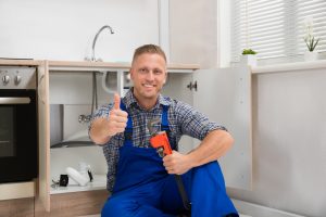 Plumber With Adjustable Wrench In Kitchen Room