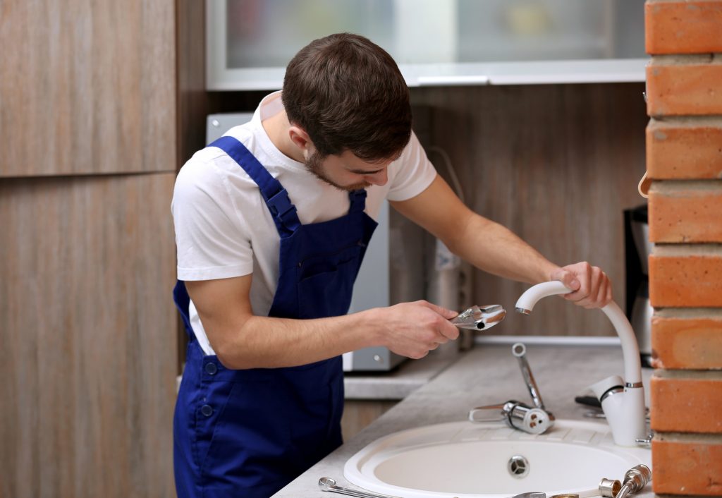 San Antonio plumber working in kitchen