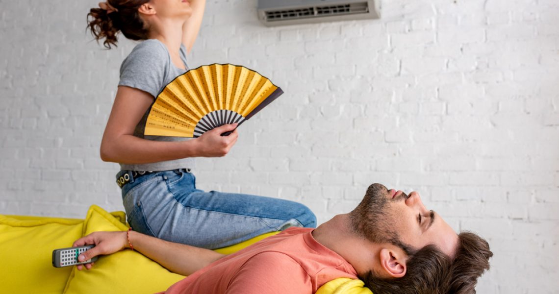 Couple Sitting Under Air Conditioner