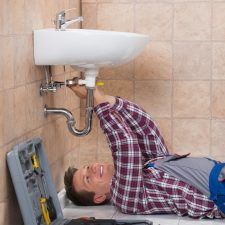San Antonio Plumber Lying On Floor Fixing Sink