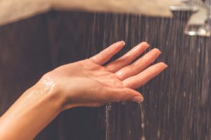 woman's hand under water in shower